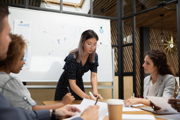 istock Participants listen asian leader explain project details during meeting 1181590498