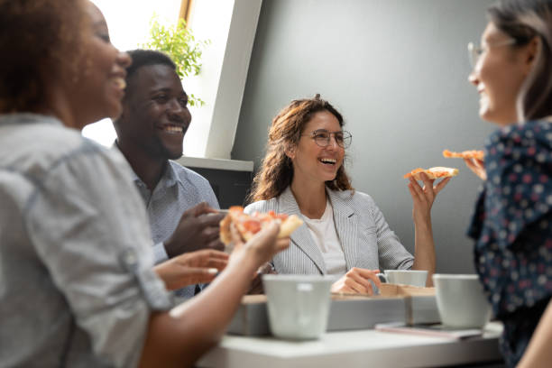 istock Multiracial company members having lunch eating pizza during break 1181590499