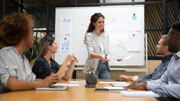 istock Diverse staff and business trainer starting seminar giving learning material 1181590533