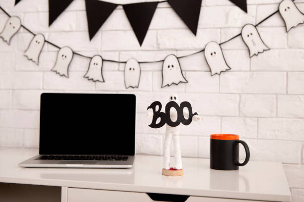 istock Office Halloween atmosphere. open laptop with blank screen 1181591419