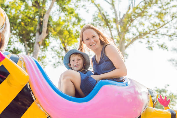 mamã e filho que têm o divertimento em um parque de diversões - blurred motion clothing mother offspring - fotografias e filmes do acervo