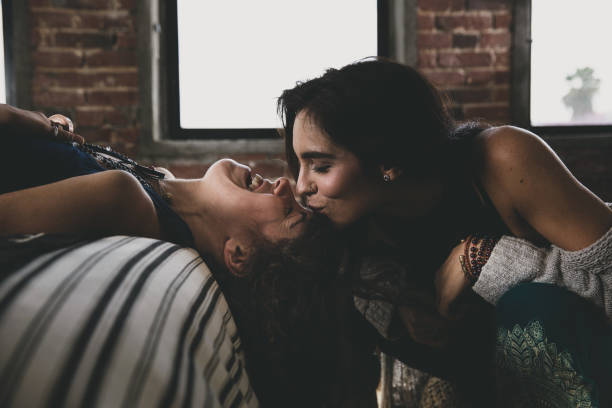 две ласковые женщины дома - lesbian homosexual kissing homosexual couple стоковые фото и изображения