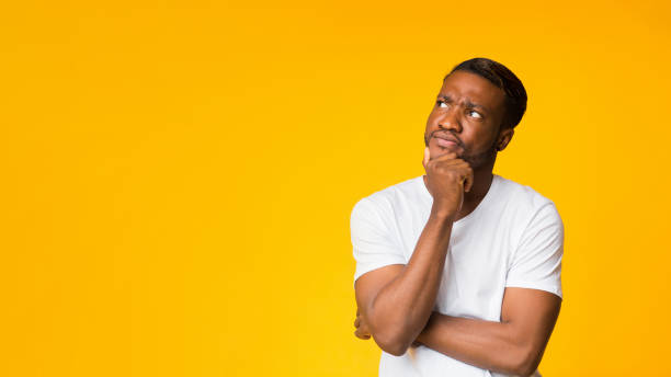 istock Afro Man Thinking Touching Chin Standing Over Yellow Background, Panorama 1181593103
