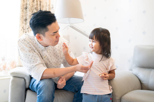 istock Cute daughter feeding her father 1181593113
