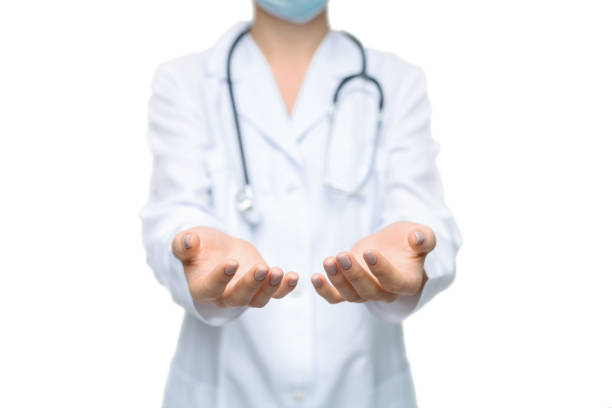 Unrecognizable female doctor holding some invisible items with both hands on white background