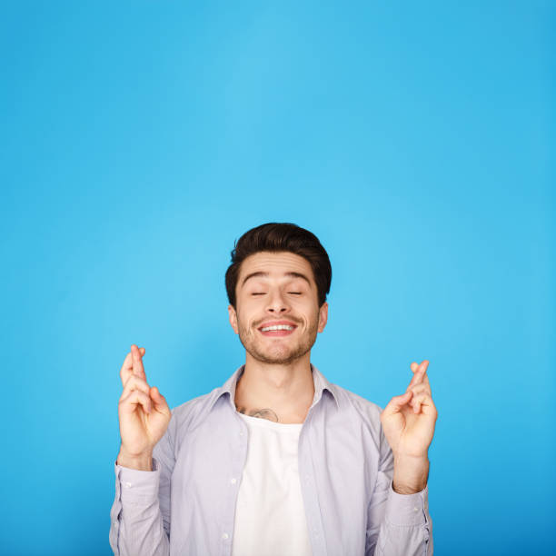 istock Hopes for fortune. Guy crossing fingers, making wish 1181595099