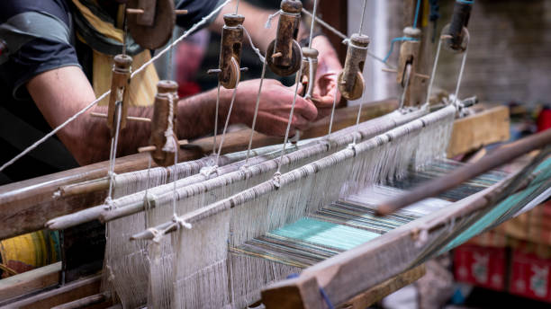 istock Iranian man crafting a wool carpet on the cotton strings in the carpet workshop 1181596475