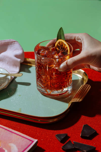 Negroni cocktail Negroni, an unforgivable IBA (international bartender association) cocktail, with 1/3 gin, 1/3 bitter, 1/3 vermut (or vermouth), in colorful and rich contemporary style. Also Americano cocktail. multi coloured glasses stock pictures, royalty-free photos & images