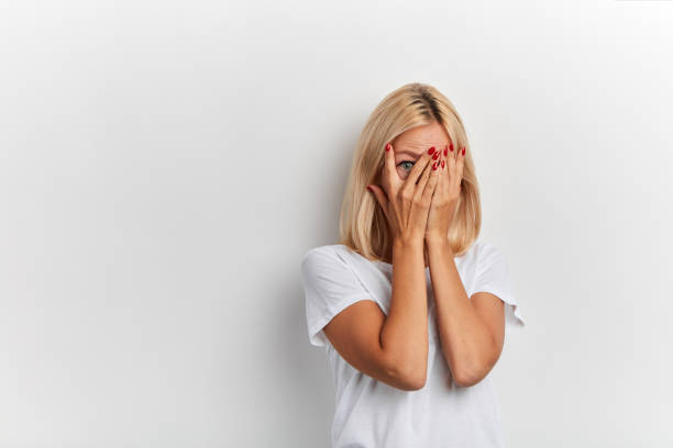 shy girl hiding behind her palms - hide imagens e fotografias de stock