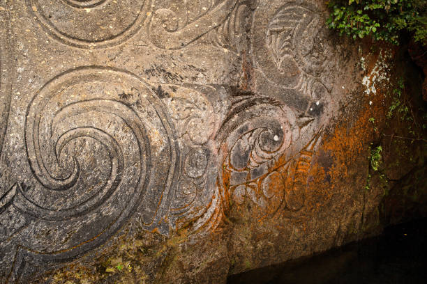 Lake Taupo, New Zealand, September 10, 2017: View from a boat of the Mine Bay Maori Rock Carvings, created by master carver Matahi Whakataka-Brightwell