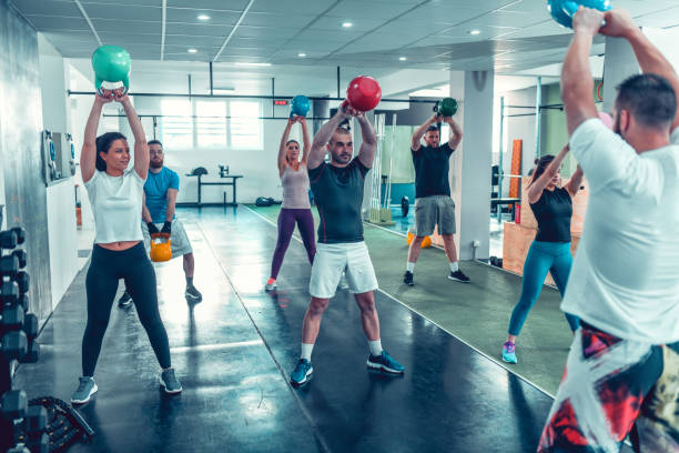istock Instructor Working On Kettlebell Swing With Team Of Athletes 1181601632