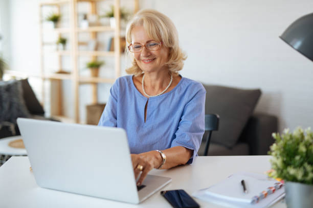 istock Senior woman using laptop at home 1181603161