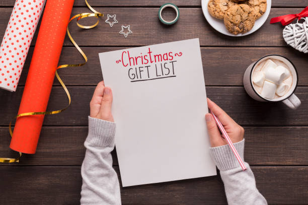 istock Woman creating Christmas gift list and drinking hot cocoa 1181603288