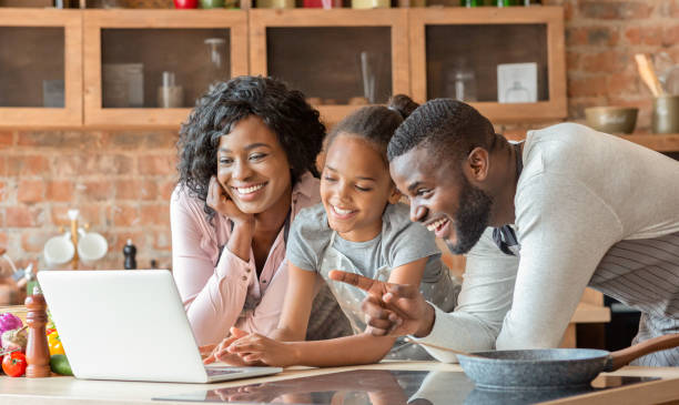istock Positive family using laptop at kitchen, looking for recipe 1181603317