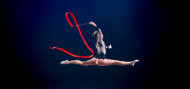 gymnast performing with ribbon - the splits ethnic women exercising imagens e fotografias de stock