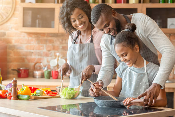 istock Afro parents teaching their daughter how to cook 1181604273