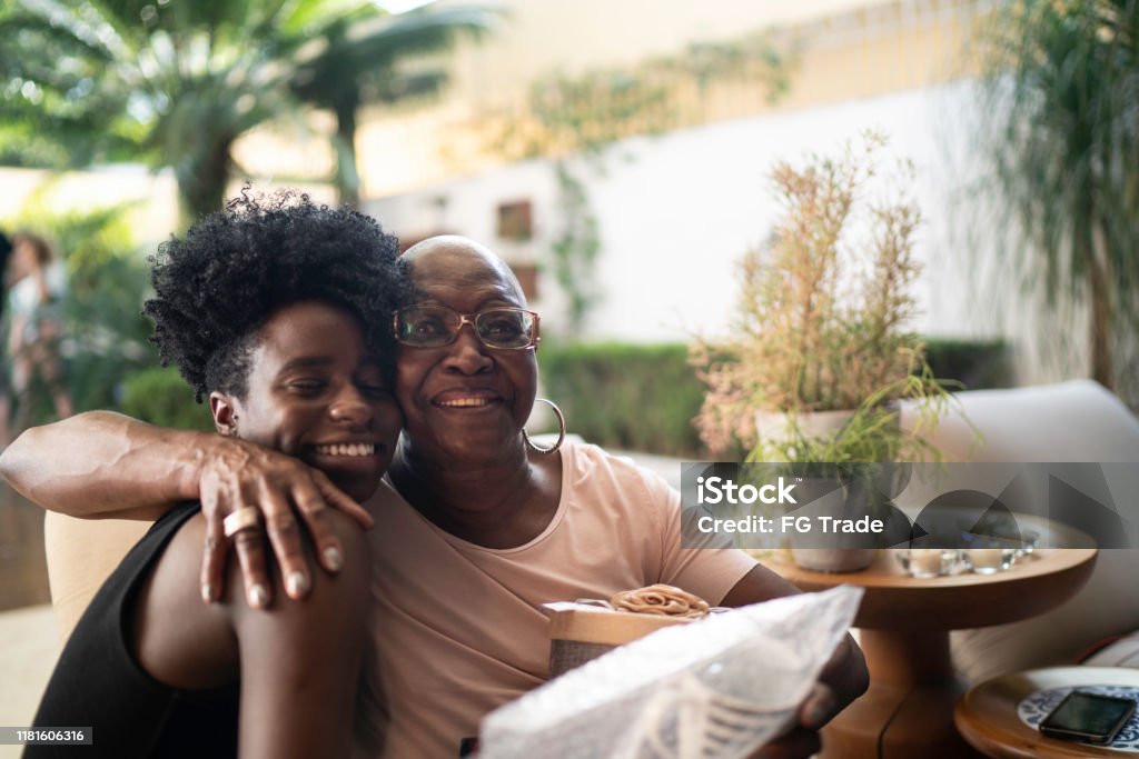 Granddaughter giving a surprise gift to grandmother Black Color Stock Photo