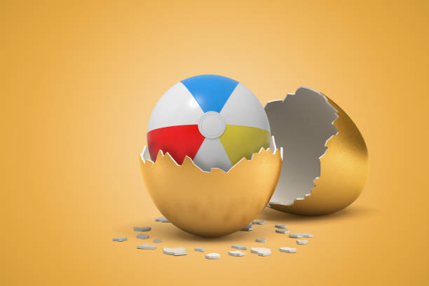 istock 3d rendering of striped inflatable ball that just hatched out from golden egg on light-ocher background. 1181607222