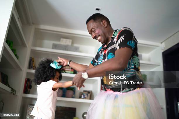 Funny Grandfather With Tutu Skirts Dancing Like Ballerinas With Grand Daughter Stock Photo - Download Image Now