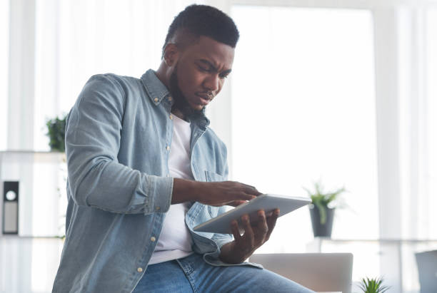 istock Portrait of concerned black employee using digital tablet in office 1181608635