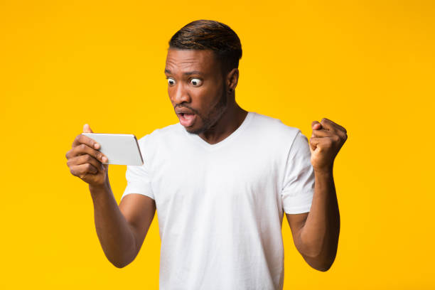 istock Shocked Black Man Looking At Smartphone, Studio Shot 1181608724