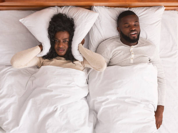 mujer cubriendo las orejas con almohada, no puede manejar el marido ronquido - couple love snoring sleeping fotografías e imágenes de stock