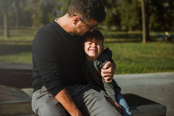 istock Father and son sitting on a skate ramp and cuddle 1181609321