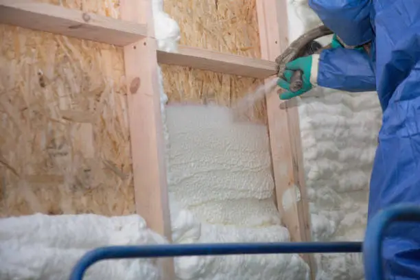 Photo of Foam is applied to the walls to warm the house at construction