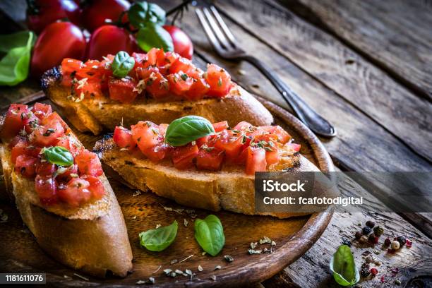 Homemade Italian Bruschetta On Rustic Wooden Table Stock Photo - Download Image Now - Bruschetta, Italian Food, Tomato