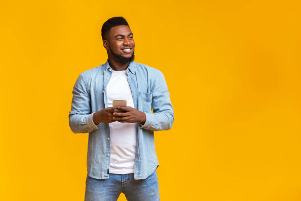 istock Handsome guy holding smartphone and looking aside at copy space 1181612466