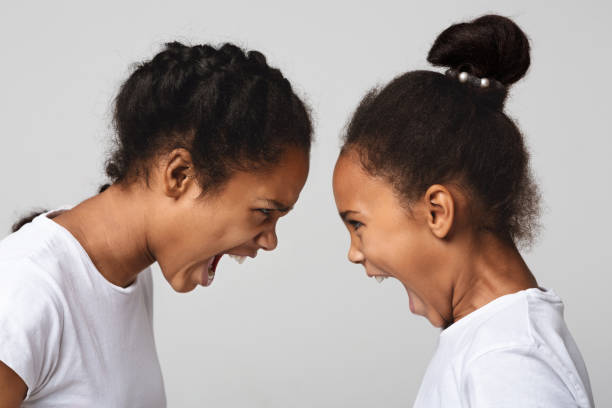istock Furious black sisters screaming at each other 1181612498
