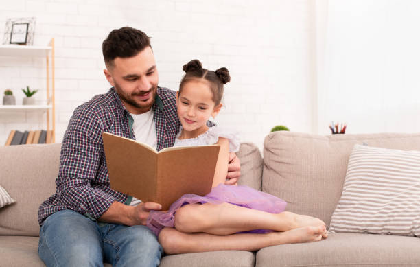 istock Caring daddy reading book to his cute daughter 1181613012