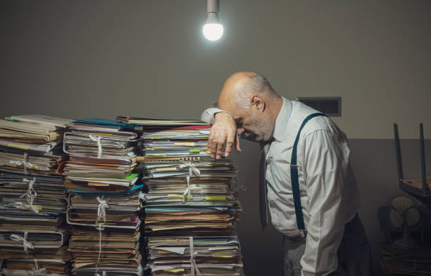 istock Desperate business executive with lots of paperwork 1181613834