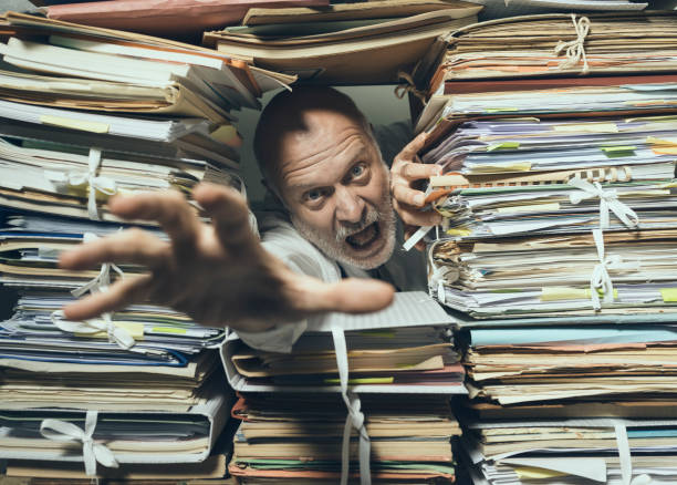 istock Panicked businessman overloaded with paperwork 1181613869