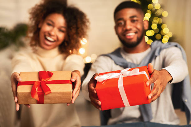 istock Excited afro couple holding xmas gift boxes and smiling 1181619141