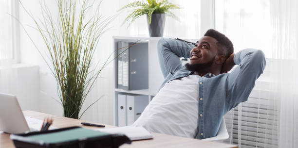 istock Black employee resting from office work, leaning back on chair 1181619476