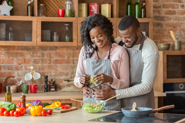 istock Husband hugging his wife from behind while cooking 1181619670