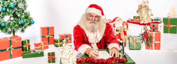 istock Santa Claus on Christmas set, looking at camera and holding pen 1181620607