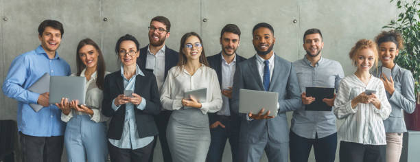 istock Young business people with different gadgets posing in office 1181620989