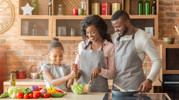 istock Young parents teaching their daughter how to make salad 1181622851