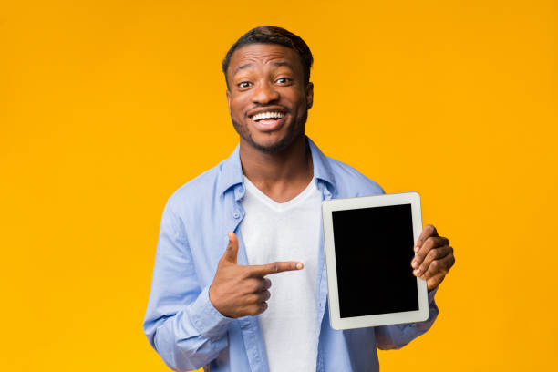 istock Afro Man Pointing Finger At Tablet Screen Standing In Studio 1181623083