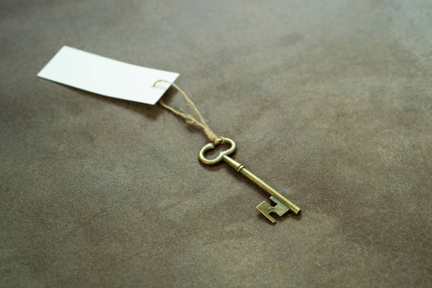 istock Old vintage brass key with white tag 1181624319