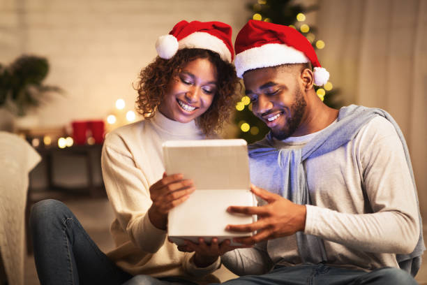 istock Christmas magic. Afro couple opening gift box 1181624349