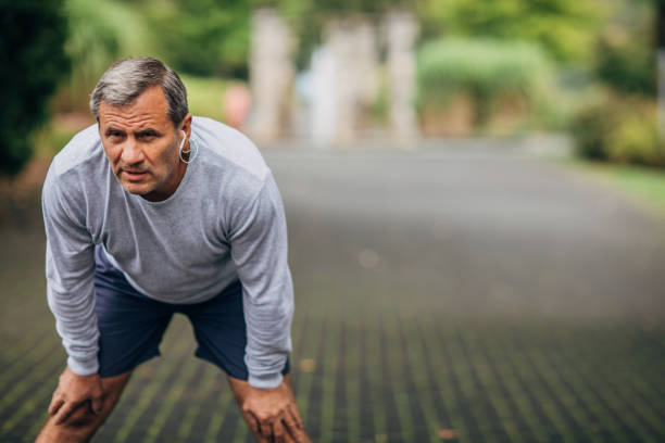 istock Senior man taking break for jogging in park 1181627278