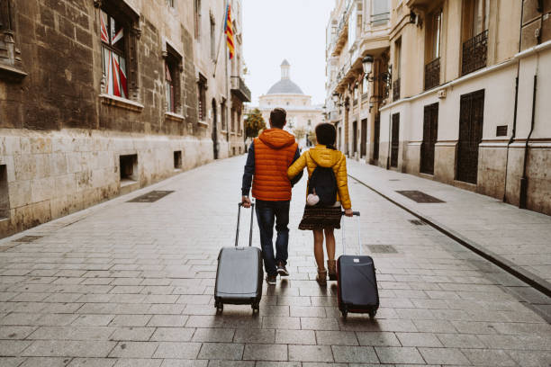 Couple visiting Valencia Rear view of couple arriving in Valencia early in the morning fall travel stock pictures, royalty-free photos & images