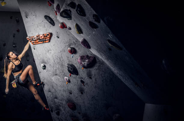 istock Sporty woman climbing artificial boulder indoors. 1181630095