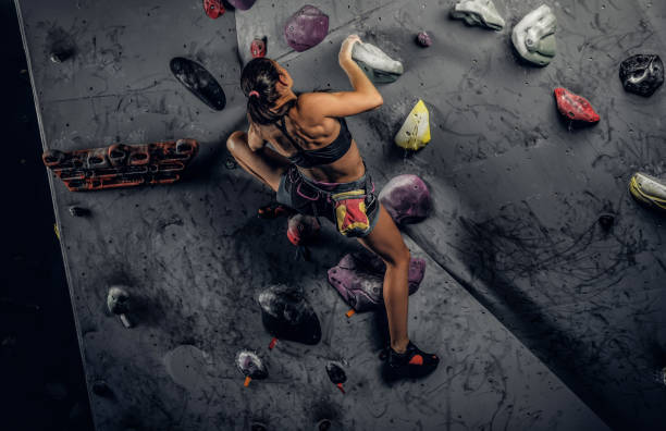 istock Sporty woman climbing artificial boulder indoors. 1181630348
