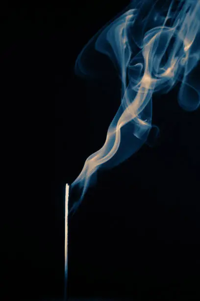 Photo of Aromatherapy Incense Stick Burning Scented Smoke Blue White Ring Smoke Black Background Copy Space