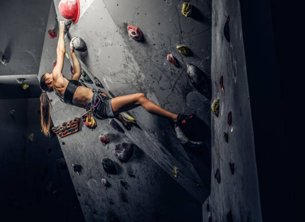 istock Sporty woman climbing artificial boulder indoors. 1181630522