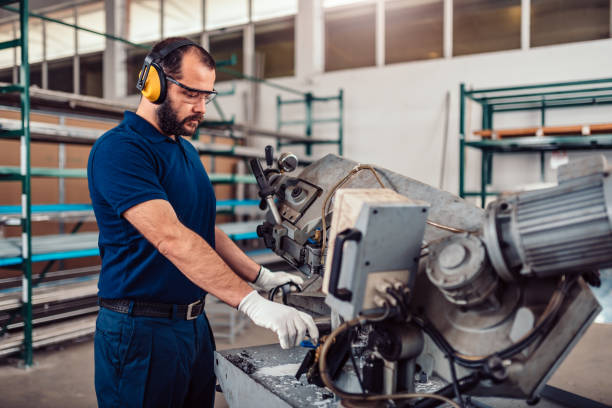 istock Factory worker operating band saw cutting machine 1181631543